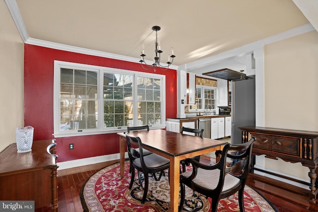 dining room featuring a chandelier, ornamental molding, and dark hardwood / wood-style floors