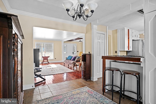 foyer featuring dark tile patterned flooring, an inviting chandelier, and ornamental molding