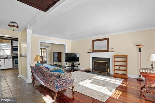 living room featuring ornamental molding, a notable chandelier, and dark wood-type flooring