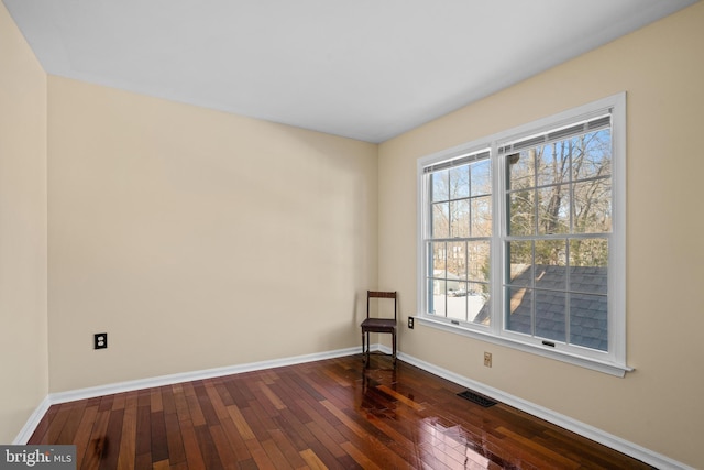 unfurnished room featuring a healthy amount of sunlight and dark wood-type flooring