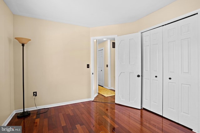 unfurnished bedroom featuring a closet and hardwood / wood-style flooring