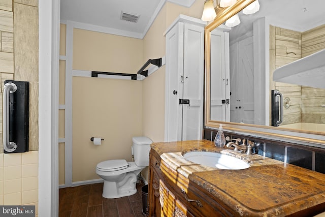 bathroom featuring ornamental molding, vanity, and toilet