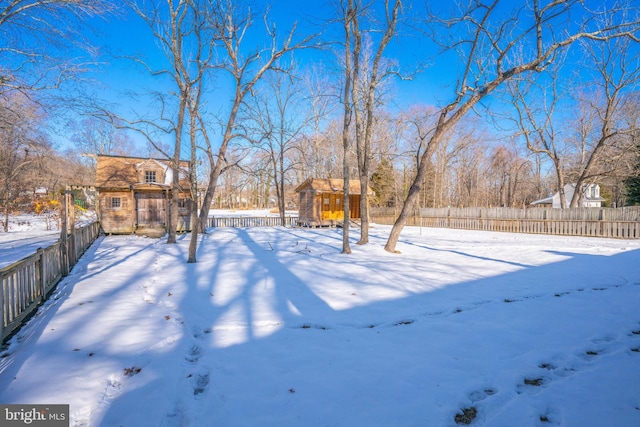 yard layered in snow with an outbuilding