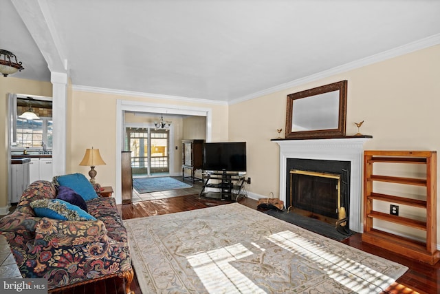 living room with dark hardwood / wood-style flooring, an inviting chandelier, and crown molding