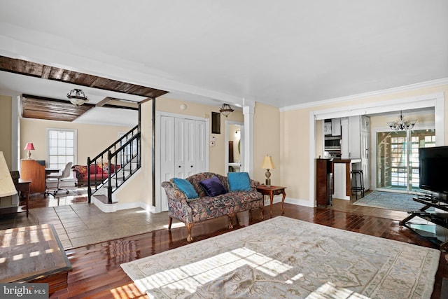 living room featuring a healthy amount of sunlight, dark hardwood / wood-style flooring, and an inviting chandelier