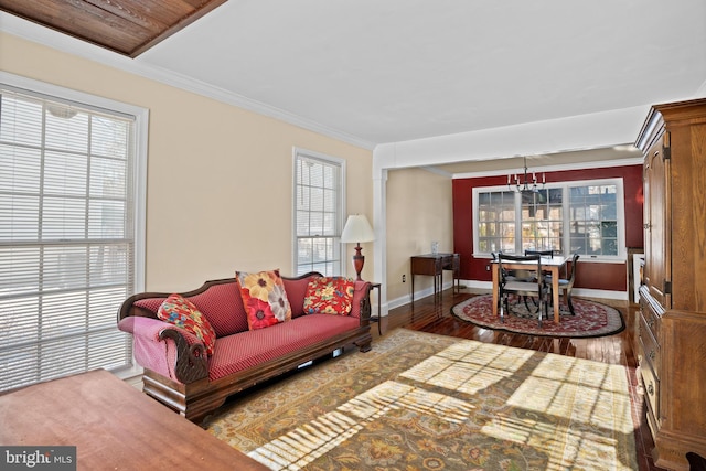 living room with a notable chandelier, ornamental molding, and hardwood / wood-style floors