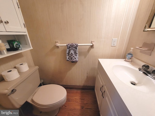 bathroom with toilet, hardwood / wood-style floors, and vanity