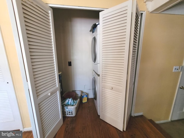 laundry area featuring dark wood-type flooring and stacked washer and dryer