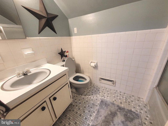 full bathroom featuring shower / bath combination with glass door, tile patterned floors, vanity, tile walls, and toilet