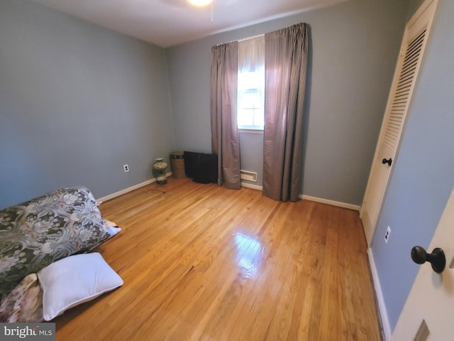 interior space with light hardwood / wood-style floors, a baseboard heating unit, and a closet