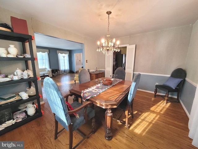 dining space with hardwood / wood-style flooring and a chandelier