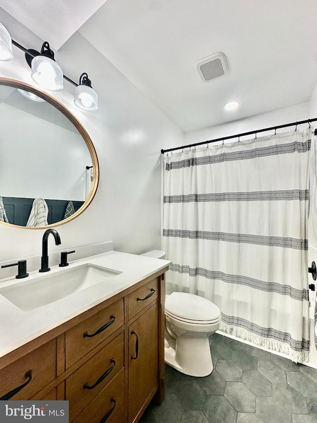 bathroom with curtained shower, toilet, and vanity