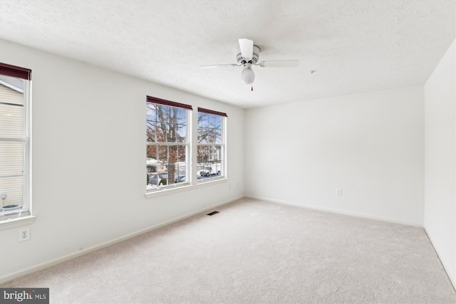 carpeted empty room with a textured ceiling and ceiling fan