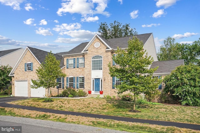 view of front of property featuring a garage and a front lawn