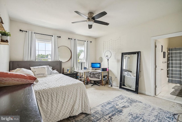 carpeted bedroom with multiple windows, connected bathroom, and ceiling fan