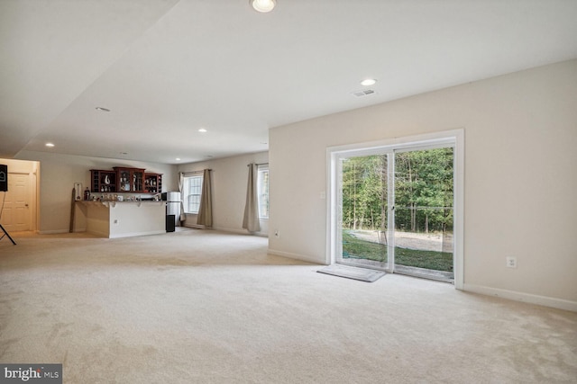 unfurnished living room featuring plenty of natural light and light colored carpet