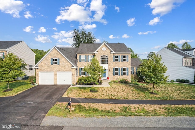 view of front of house with a garage and a front lawn