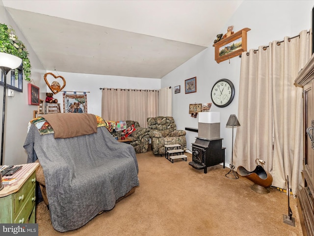 sitting room with lofted ceiling, carpet, and a wood stove