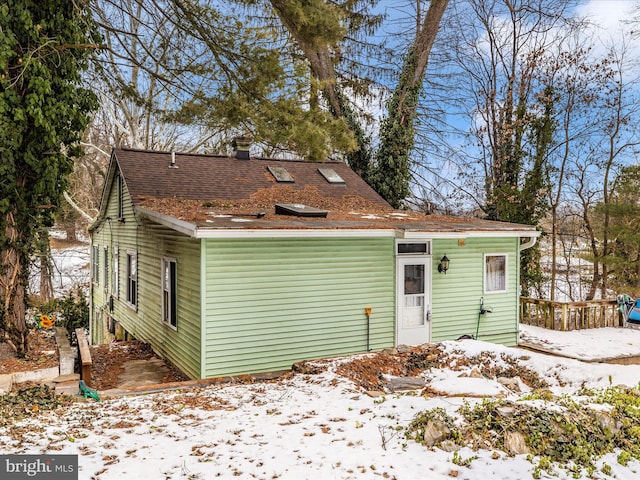 view of snow covered rear of property