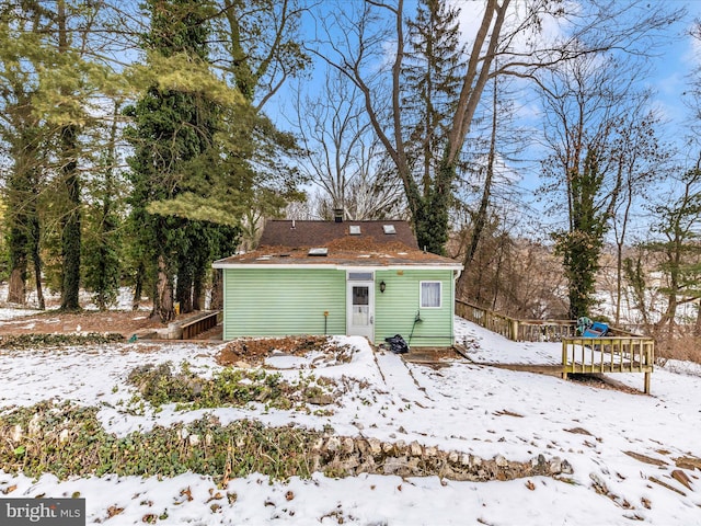 view of snow covered rear of property