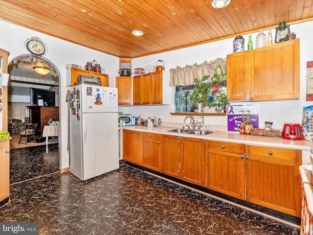 kitchen with white fridge, wooden ceiling, and sink