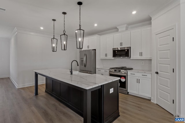 kitchen with pendant lighting, white cabinetry, a center island with sink, and stainless steel appliances