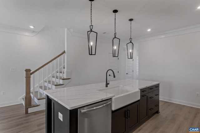 kitchen with pendant lighting, dishwasher, a center island with sink, sink, and light hardwood / wood-style floors