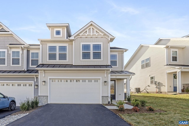 multi unit property featuring cooling unit, a garage, and a front yard