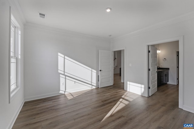 empty room featuring dark wood-type flooring and crown molding