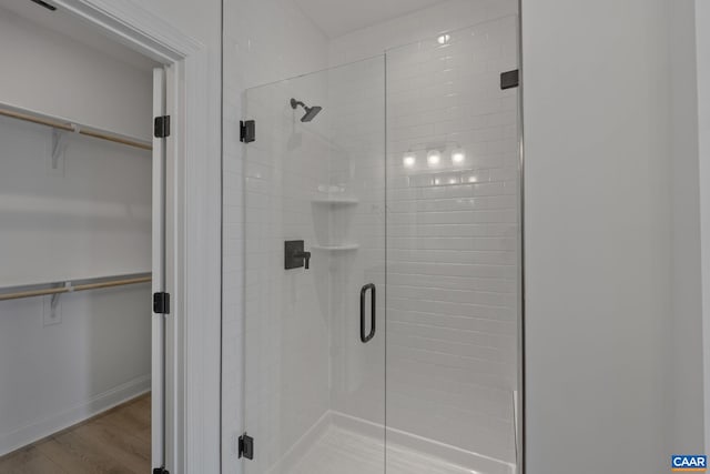 bathroom featuring hardwood / wood-style flooring and a shower with shower door