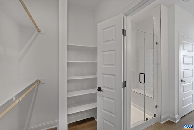 bathroom featuring hardwood / wood-style floors and a shower with shower door