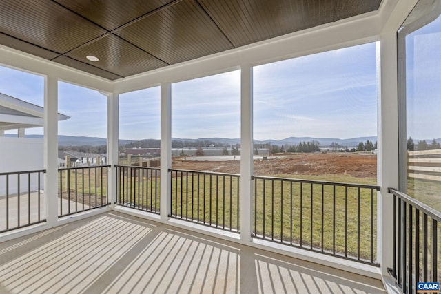 unfurnished sunroom with a mountain view and wood ceiling