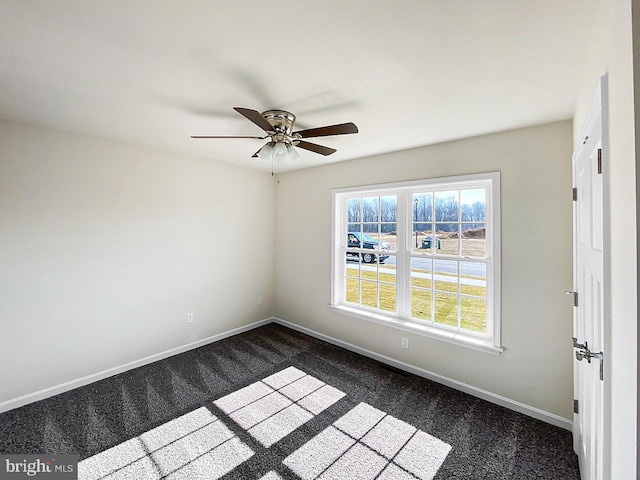 empty room with dark carpet and ceiling fan