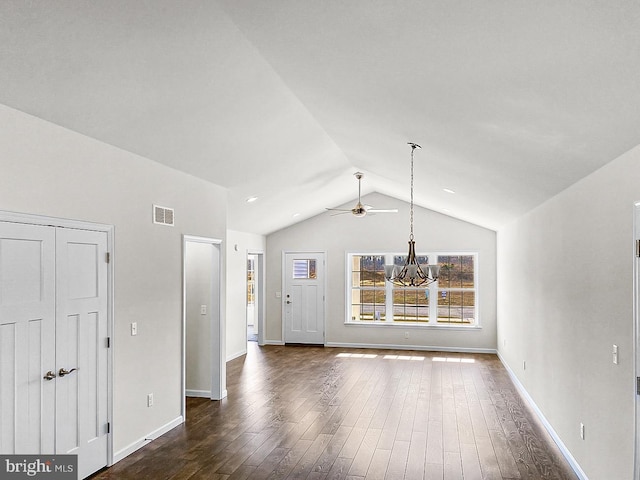 unfurnished living room with vaulted ceiling, dark hardwood / wood-style floors, and ceiling fan with notable chandelier