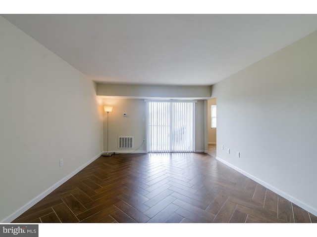 unfurnished room featuring dark parquet floors