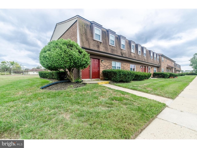 townhome / multi-family property with a front lawn