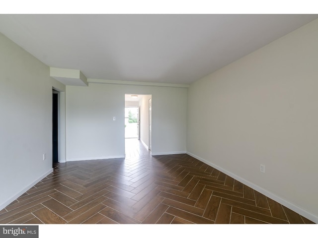 spare room featuring dark parquet floors