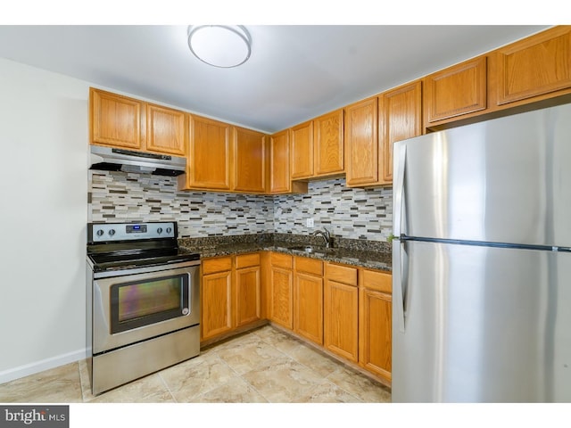 kitchen with sink, stainless steel appliances, dark stone countertops, and backsplash