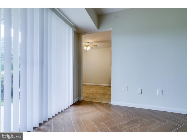 spare room featuring ceiling fan and parquet floors