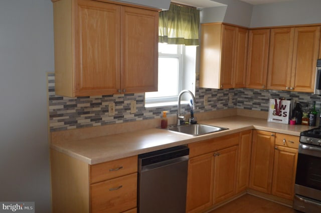 kitchen with decorative backsplash, sink, and stainless steel appliances