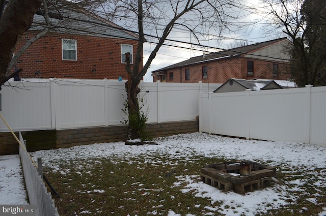 yard covered in snow featuring a fire pit