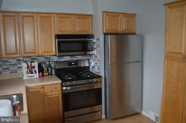 kitchen featuring decorative backsplash and appliances with stainless steel finishes