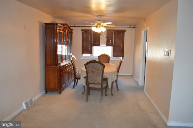 carpeted dining room featuring ceiling fan