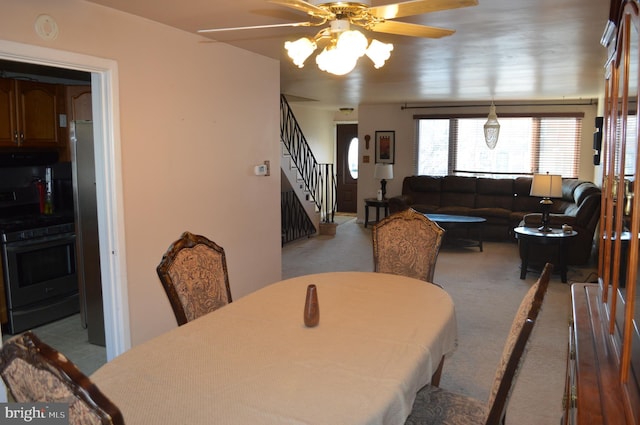 dining area with ceiling fan and light carpet