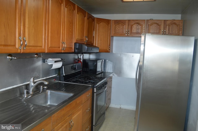 kitchen with sink, extractor fan, dark stone counters, and appliances with stainless steel finishes