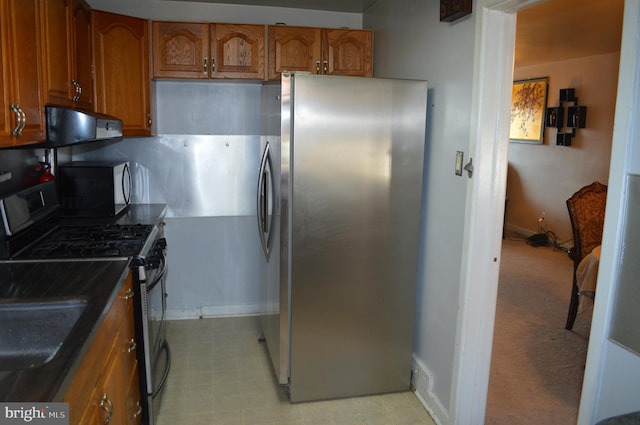 kitchen with exhaust hood and appliances with stainless steel finishes