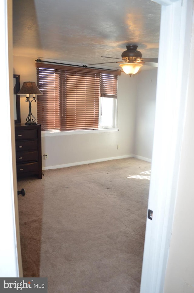 carpeted spare room featuring ceiling fan