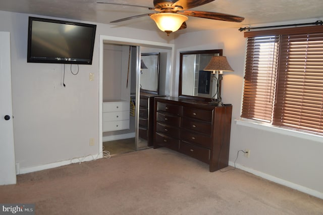 unfurnished bedroom with a closet, ceiling fan, and light carpet