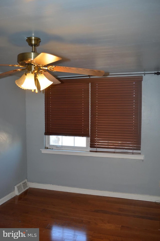 spare room featuring dark wood-type flooring and ceiling fan