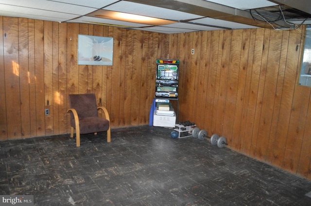 unfurnished room featuring wooden walls